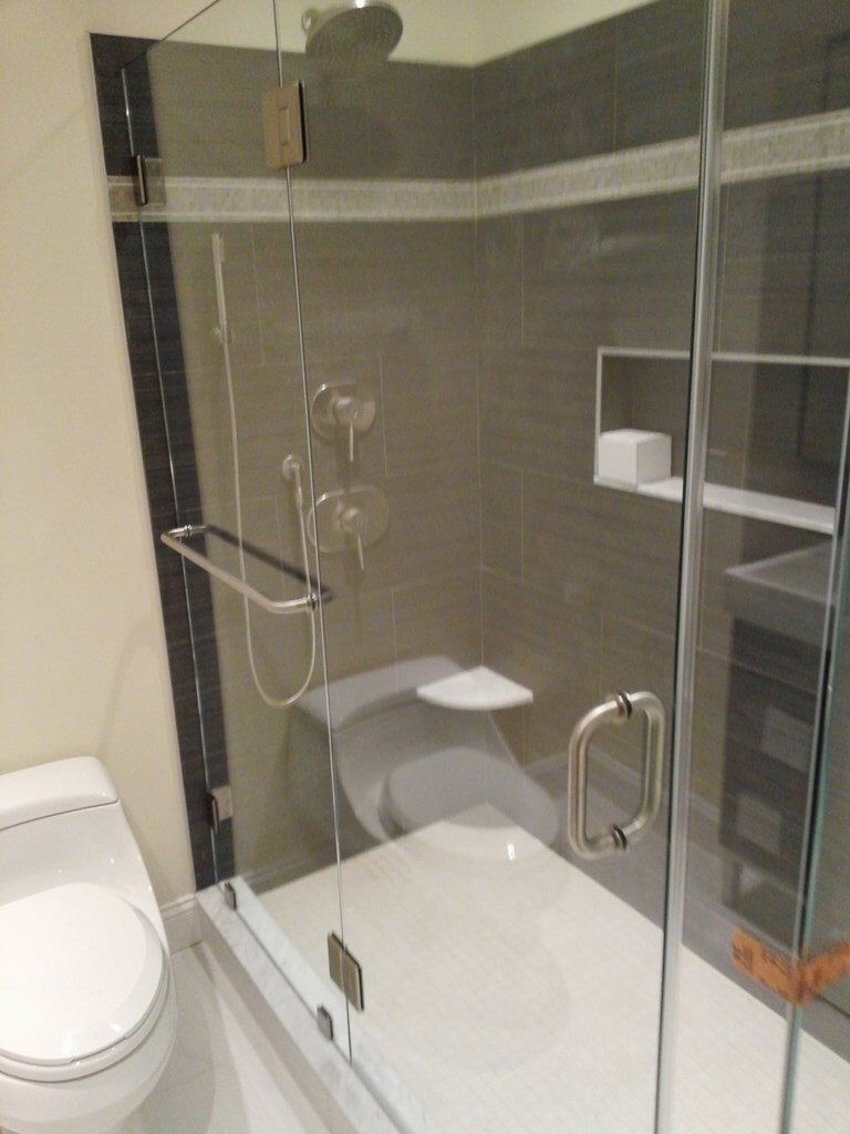 A bathroom with a toilet a bathtub and a shower stall