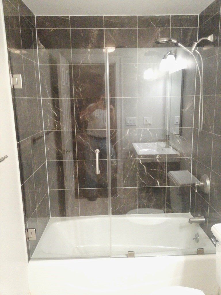 A bathroom with a bathtub , sink , mirror and shower.