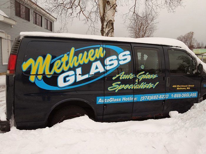 A methuen glass van is parked in the snow