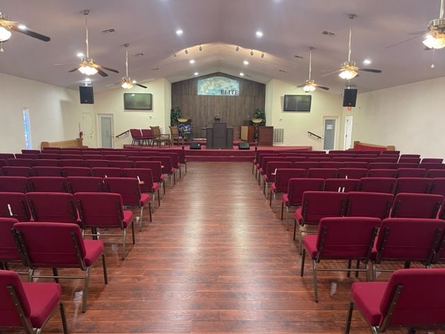 Rows of red chairs are lined up in a church