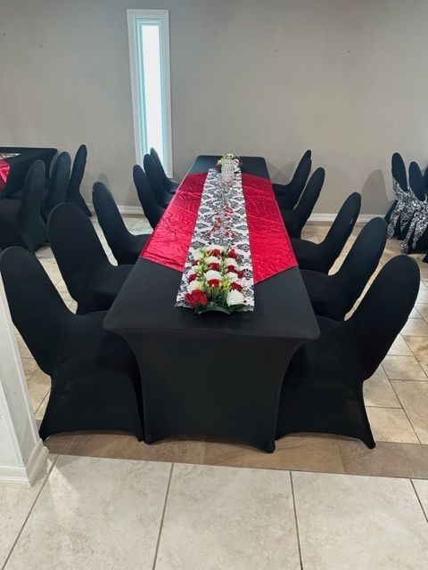A long table with black chairs and a red table runner