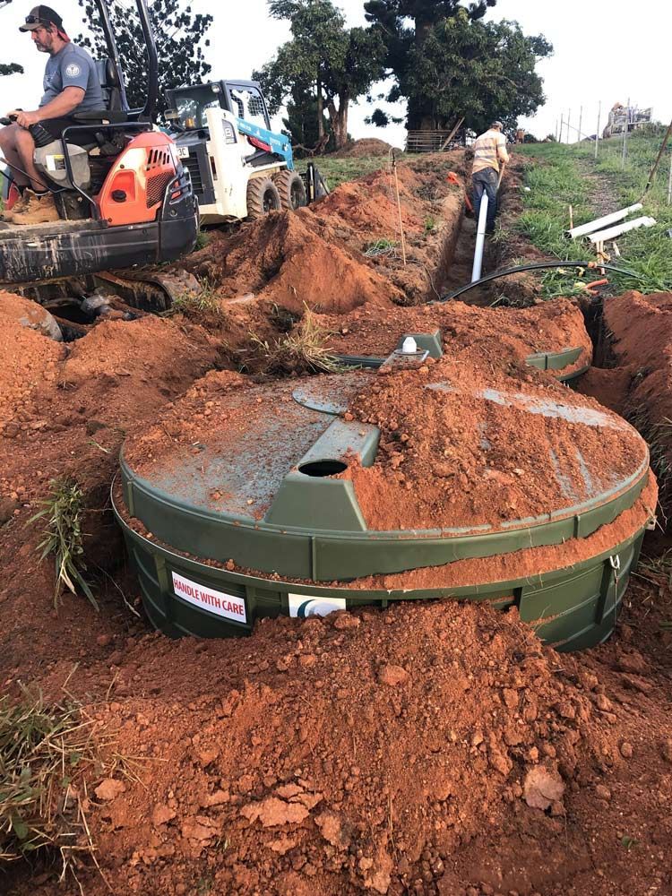 A Green Septic Tank Being Installed in a Trench — Far North Plumbing in Mourilyan, QLD