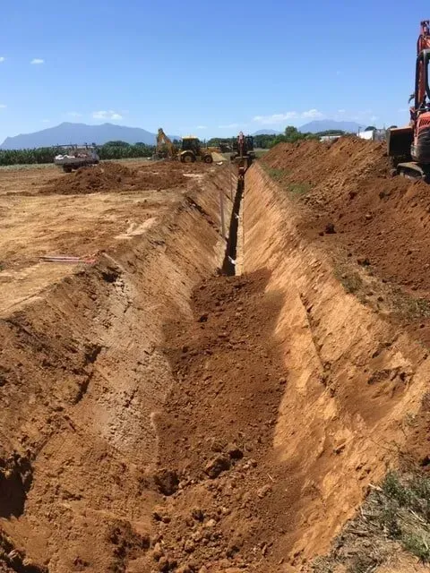 Trench Dug in a Field, With Dirt Piles Alongside — Far North Plumbing in Mourilyan, QLD