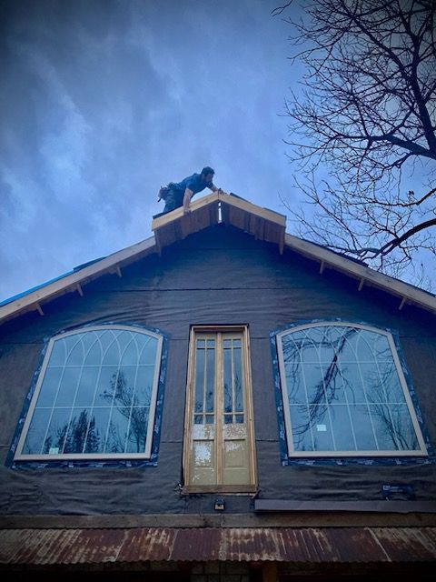 A man is working on the roof of a house.