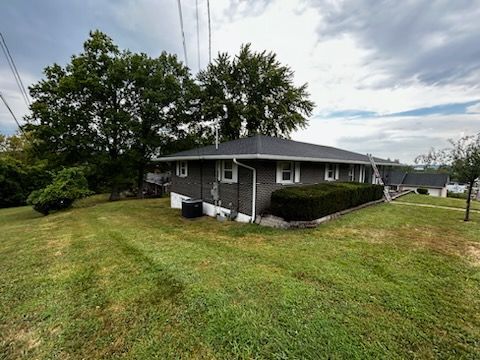 A large brick house with a roof that is being remodeled.