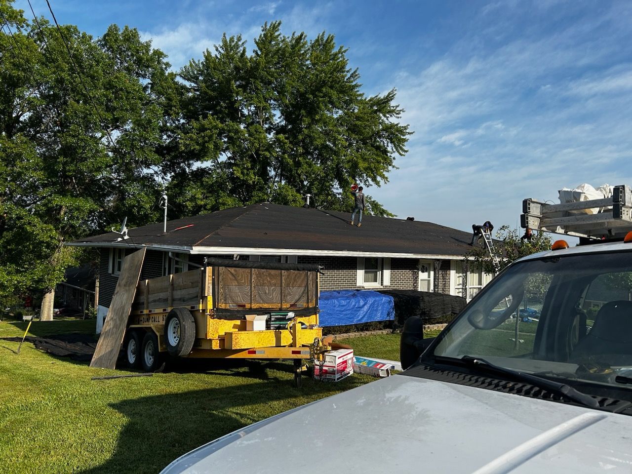 A truck is parked in front of a house with a trailer attached to it.