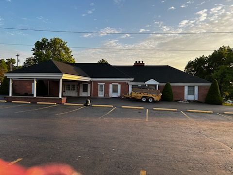 A large brick building with a trailer parked in front of it.