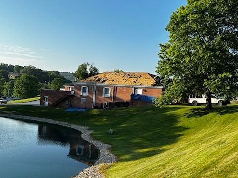 A large brick building is sitting next to a body of water.