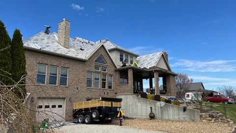 A large brick house with a trailer parked in front of it.