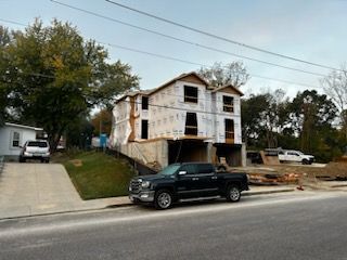 A truck is parked in front of a house under construction.