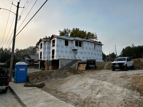 A white truck is parked in front of a building under construction.