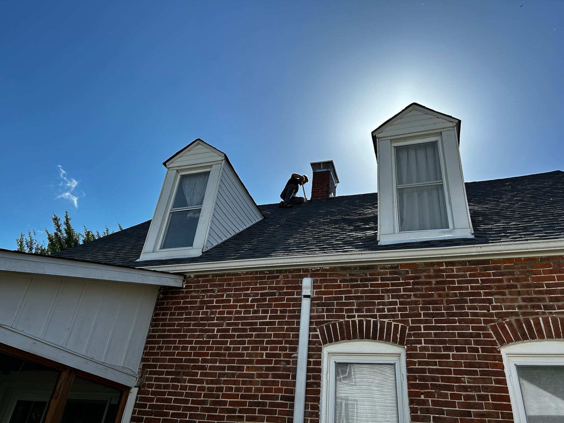A brick house with a chimney on the roof.