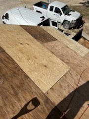 A white truck is parked on top of a wooden roof.
