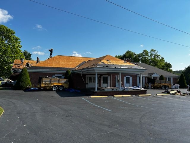 A roof is being installed on a building in a parking lot