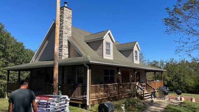 A man is standing in front of a large house.