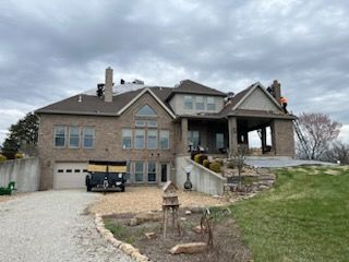 A large brick house with a car parked in front of it.