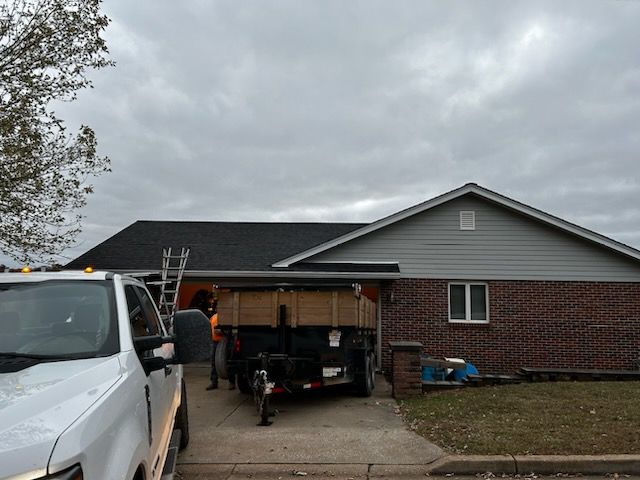 A white truck is parked in front of a brick house.