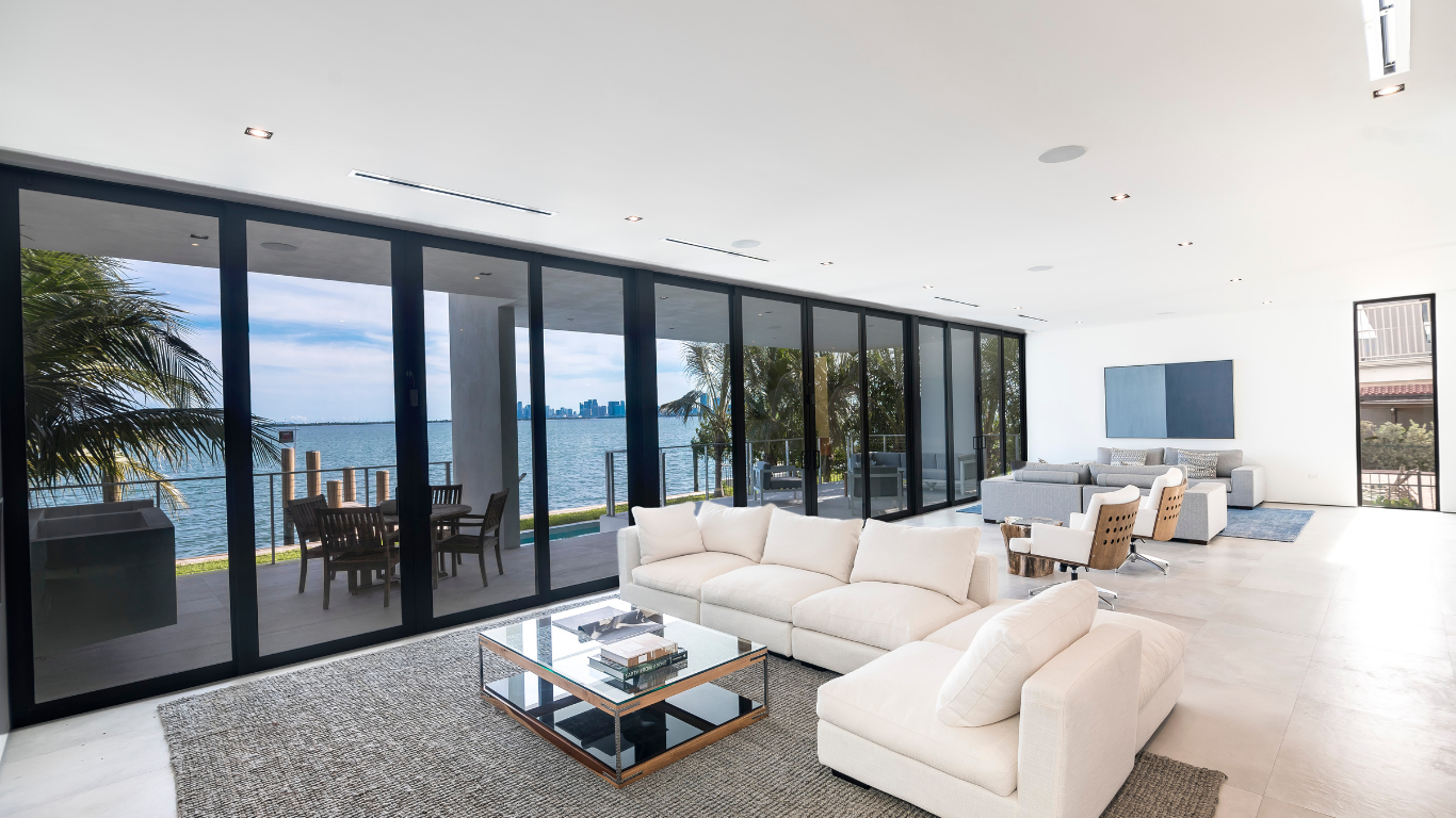 Brick home with beige trim, brown shutters, manicured lawn, and trees.