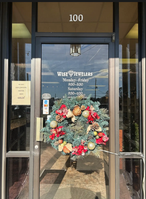 Entrance to Wise Jewelers with a holiday wreath on the glass door; address 100 above.