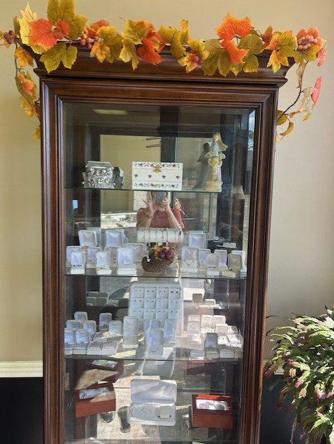 Jewelry display cabinet with fall foliage on top, filled with jewelry boxes and display cases.