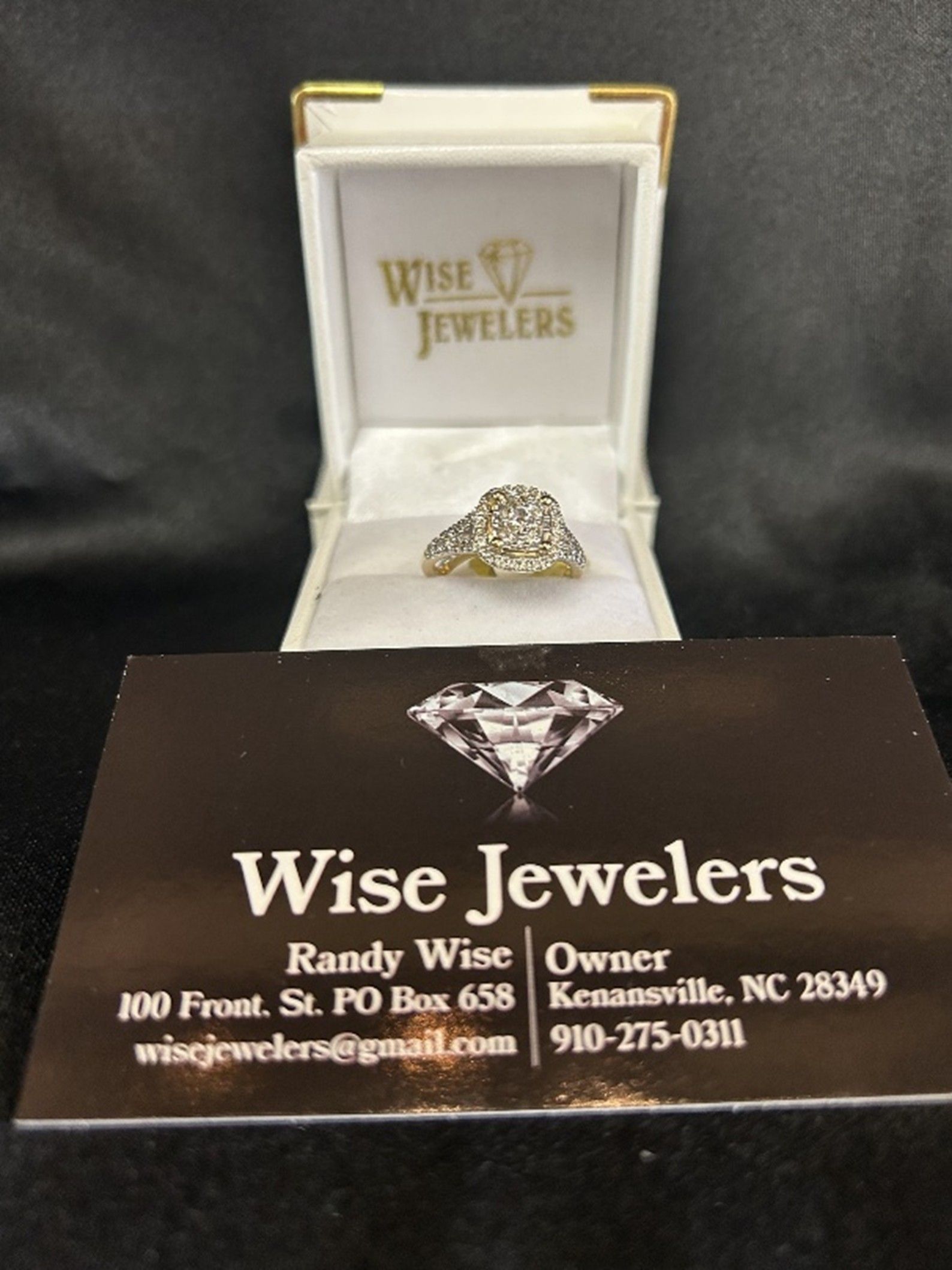Ring in a jewelry box with a Wise Jewelers business card below.