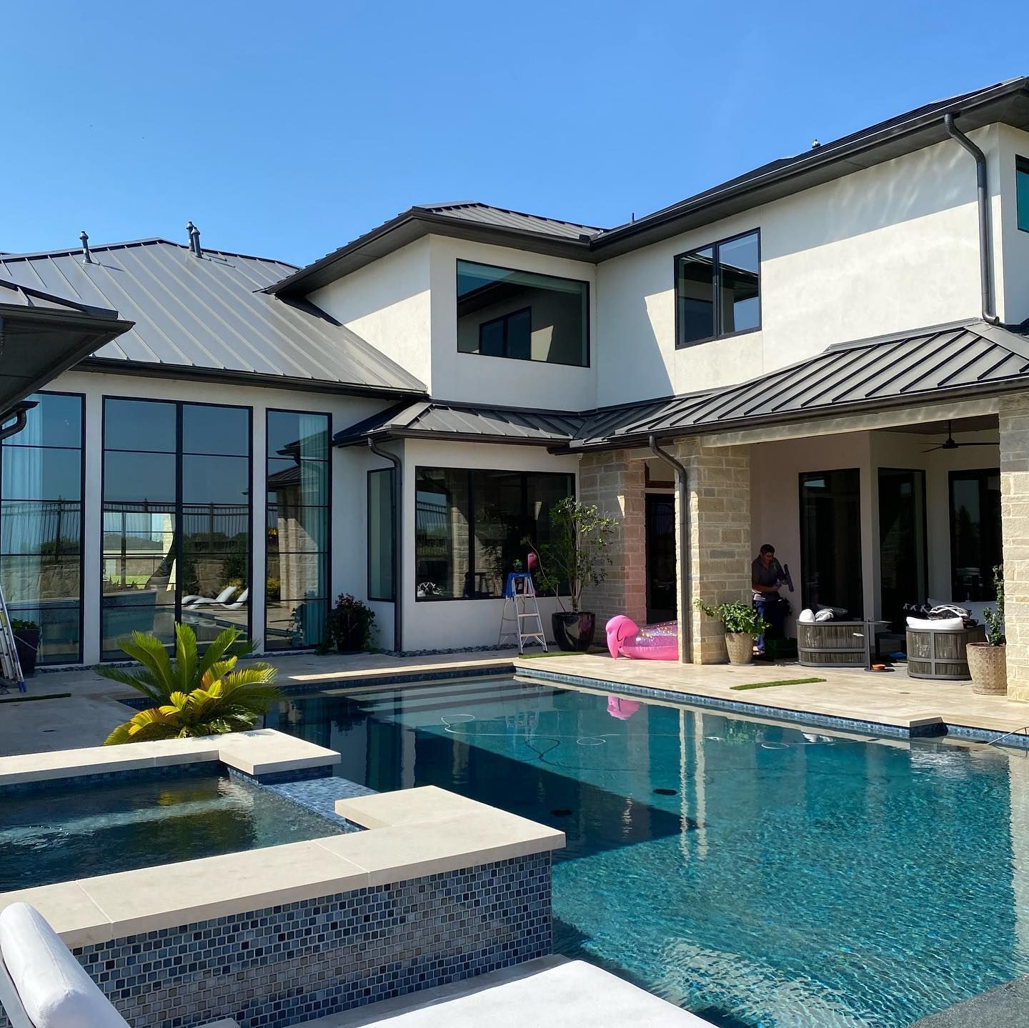 A modern home with a pool and spa on a sunny day.