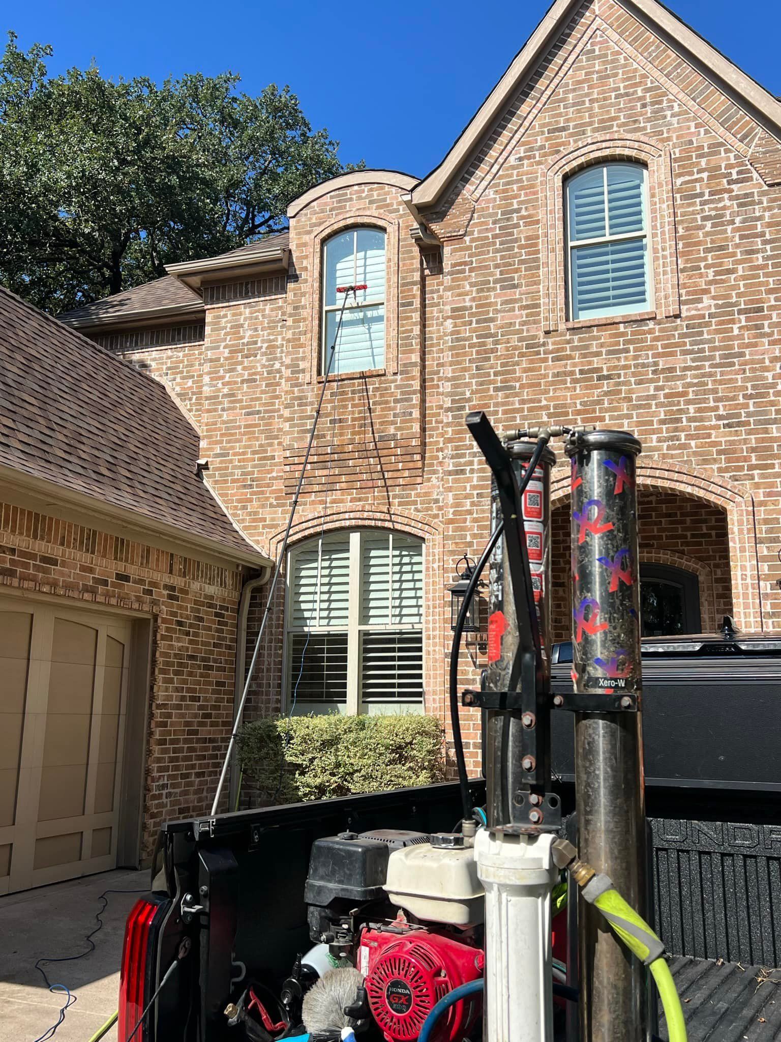 Brick house with equipment in front; likely for window cleaning.