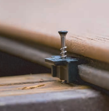 Screw and clip securing a deck board to a frame.