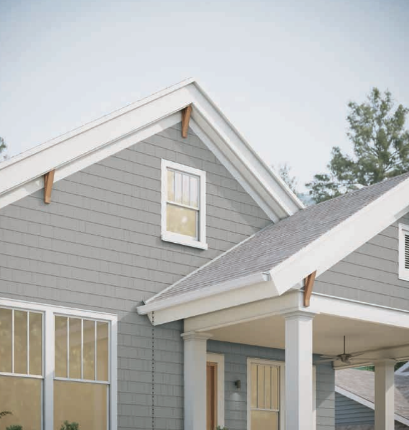 Gray house with white trim, porch, and windows. Wooden brackets support roof.