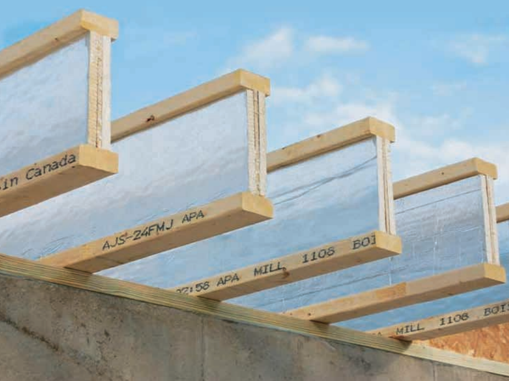 Wooden joists with reflective insulation, attached to a concrete structure, against a blue sky.