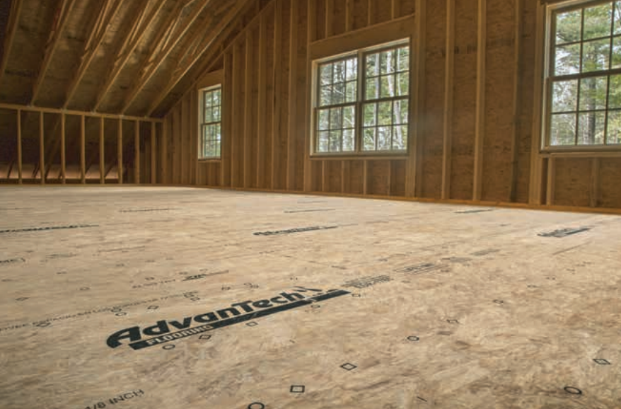 Interior of a house under construction, with wood framing and Advantech subfloor. Windows and an attic are visible.