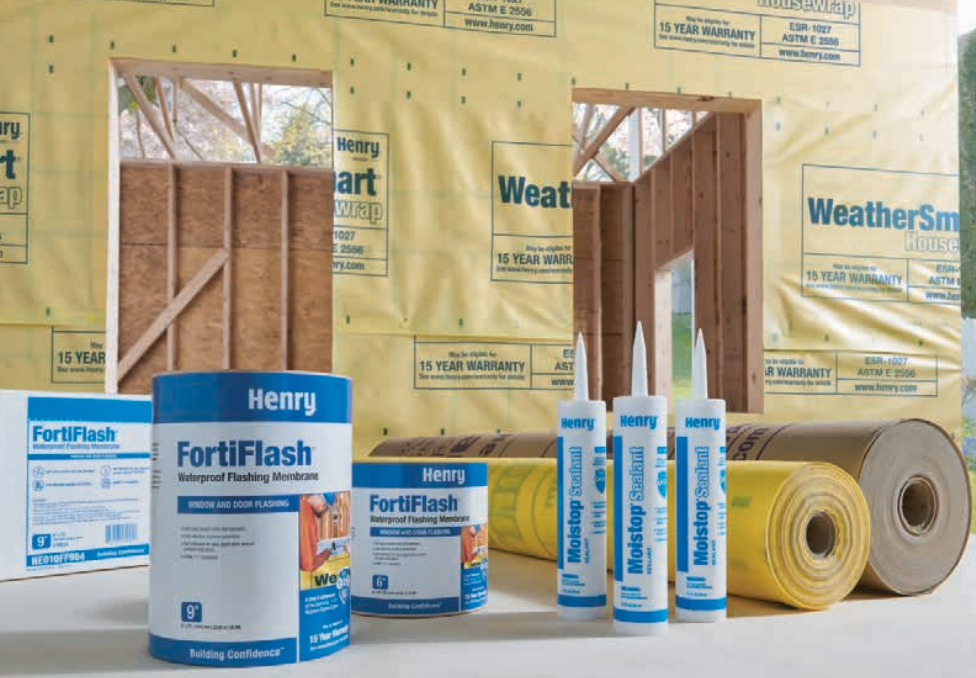 Construction scene: Henry FortiFlash flashing/sealing products, rolls, building structure with yellow WeatherSmart wrap.