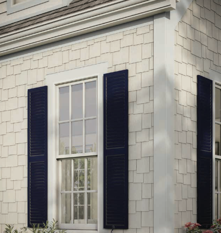 Window with blue shutters on a light-colored shingled house exterior.