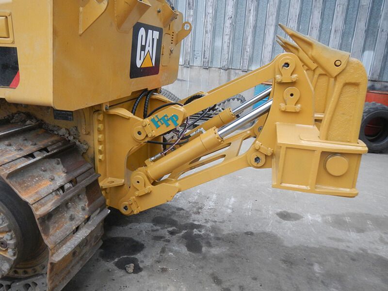 A yellow cat bulldozer is parked in a parking lot.