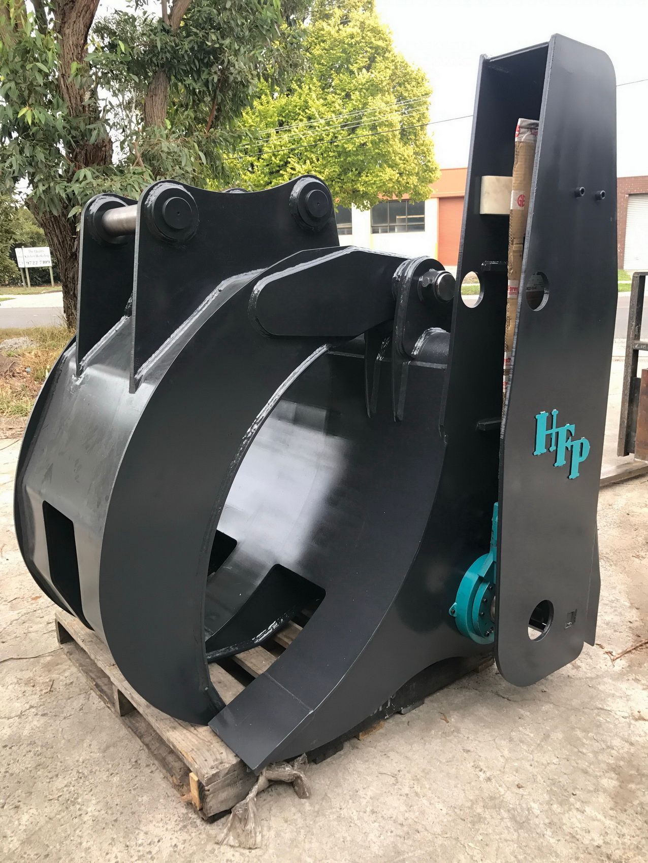 A large black metal object is sitting on top of a wooden pallet.