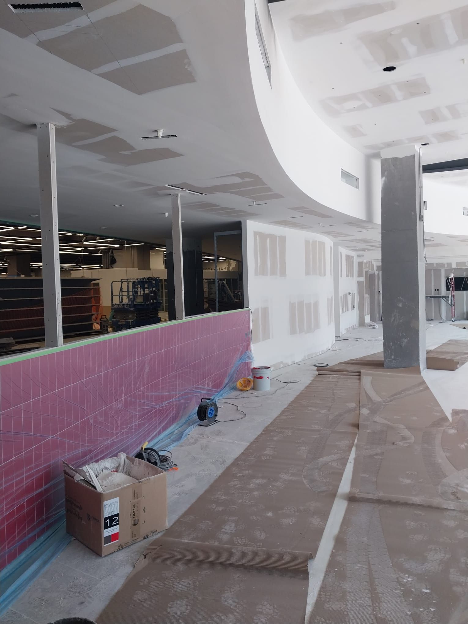 Un gran edificio en construcción con una pared rosa.