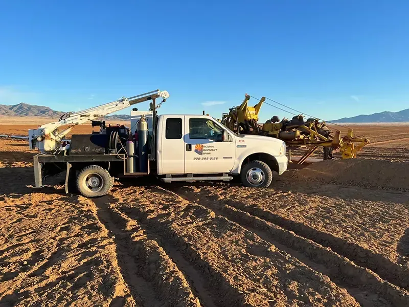 A white truck is parked in the middle of a desert.
