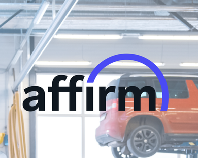 A car is being lifted in a garage with the word affirm above it | Barclay Automotive