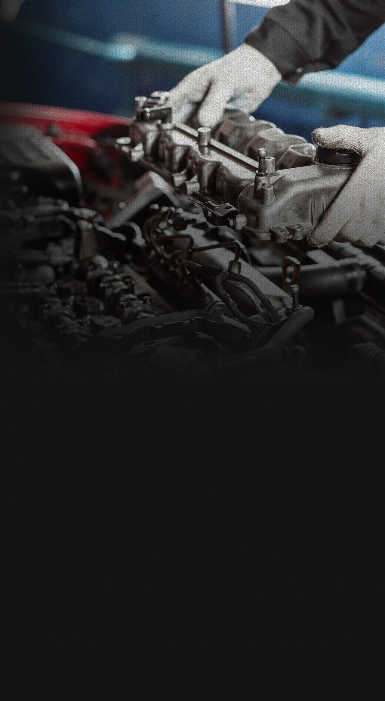 A mechanic is working on a car engine in a garage. | Barclay Automotive