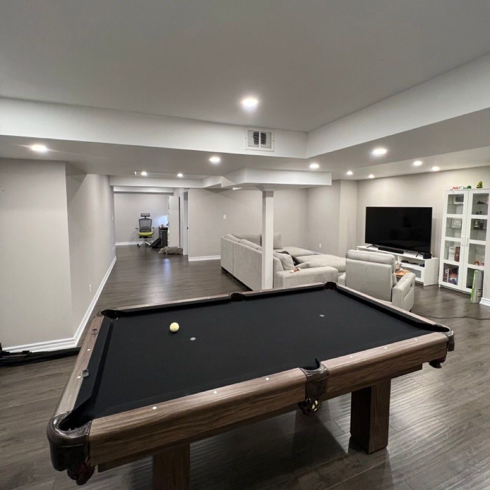 A pool table is in the middle of a living room.