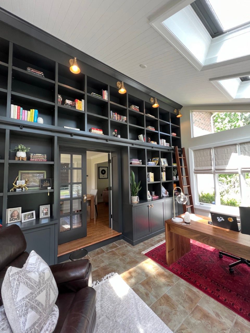A living room with lots of bookshelves and a desk