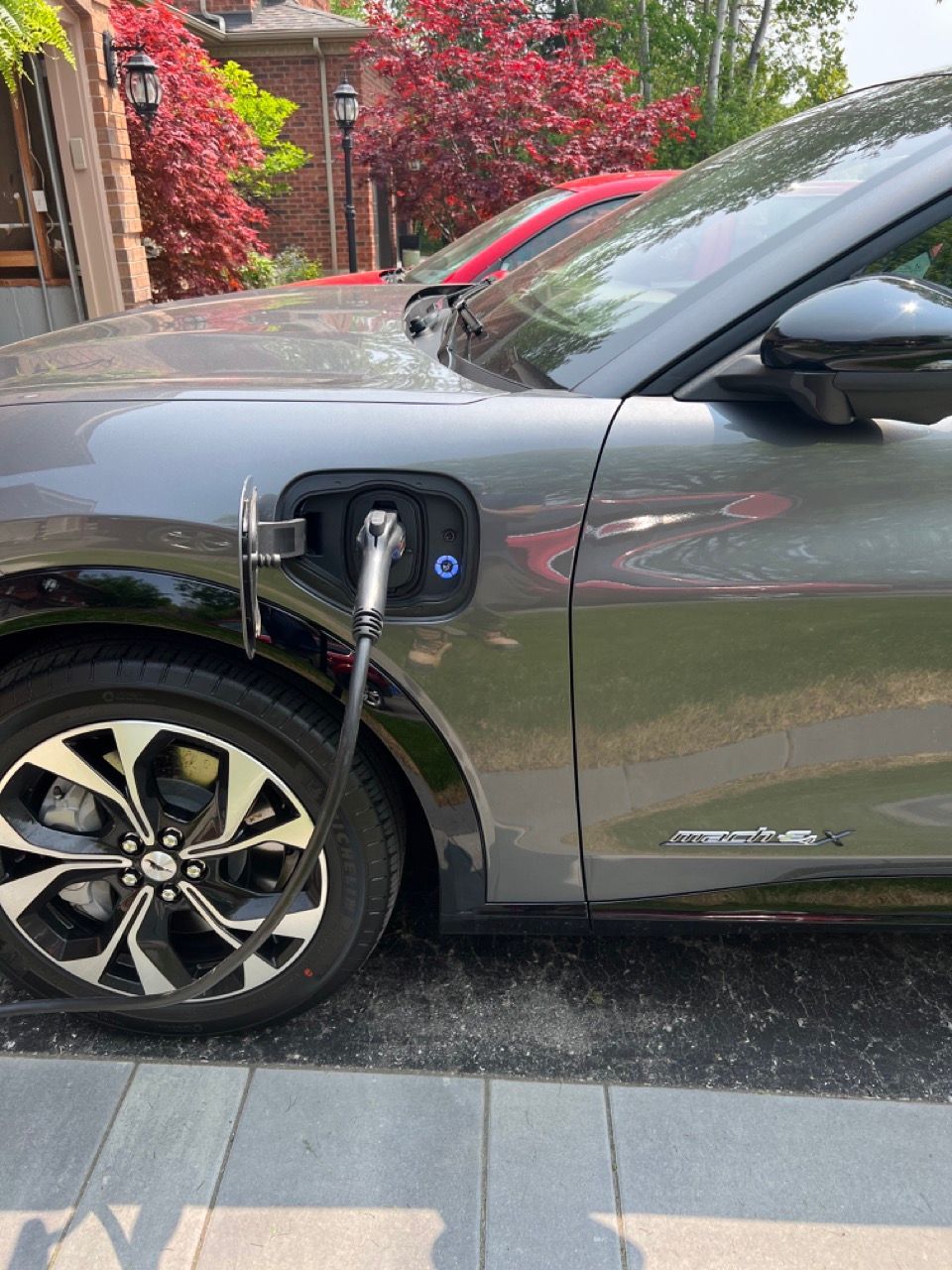A ford mustang mach e is plugged into a charging station.