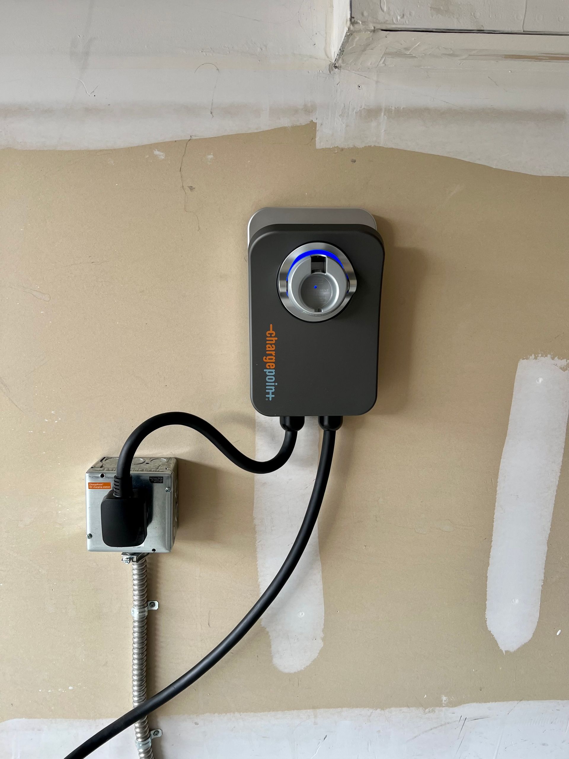 A timer is plugged into a wall outlet in a garage.