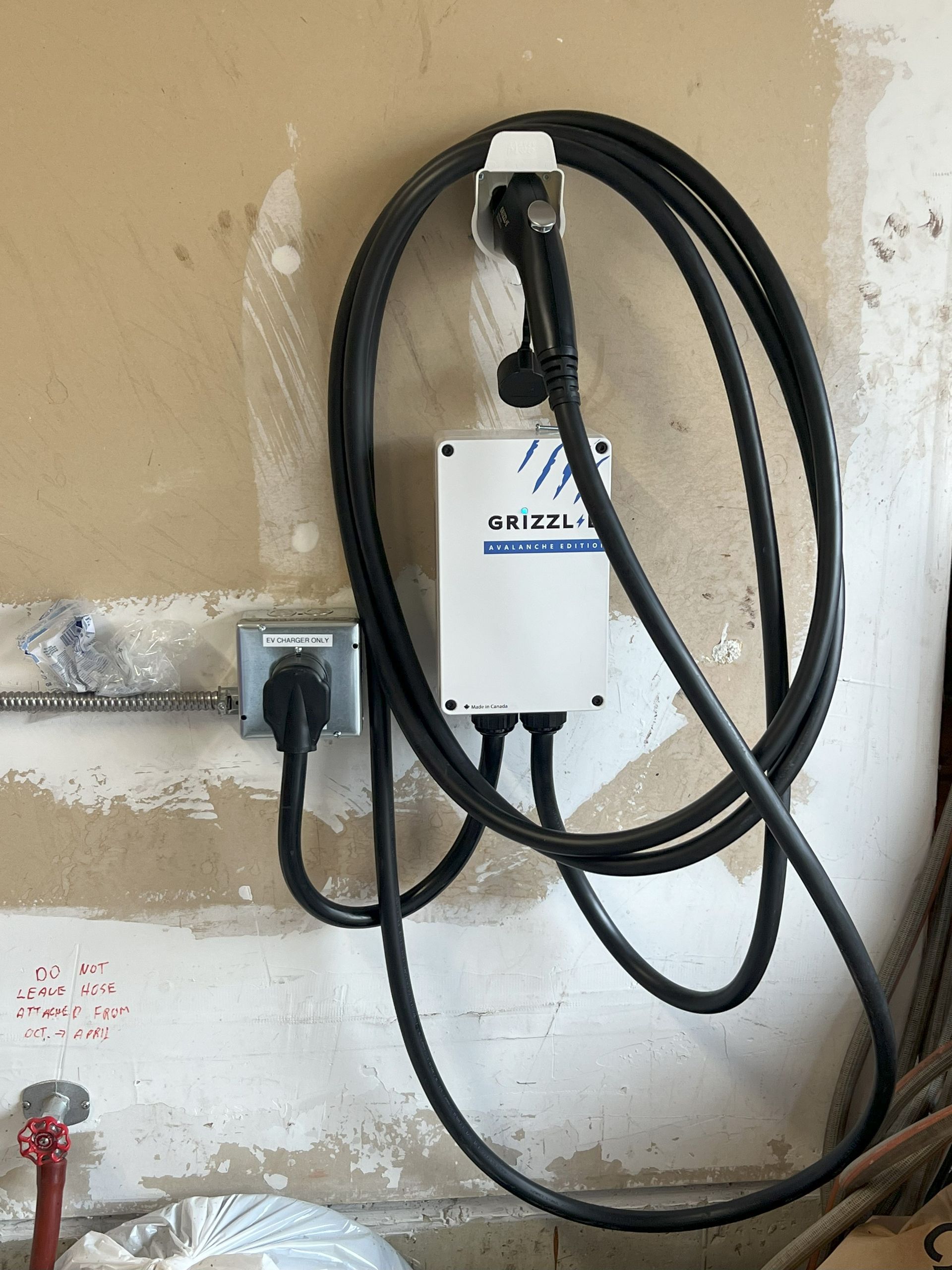A power cord is hanging from a wall next to a socket.