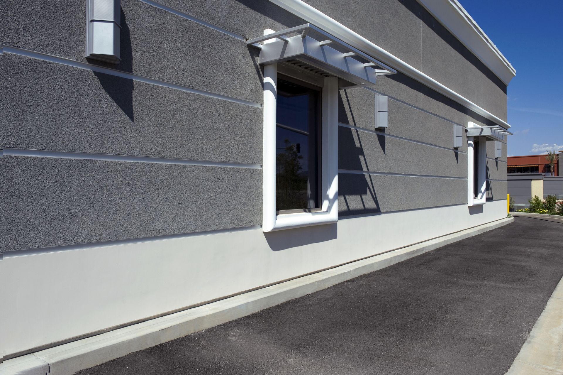 A building with a lot of windows and a driveway in front of it