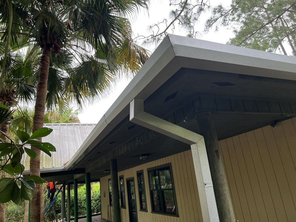 A house with a porch and a gutter on the roof.