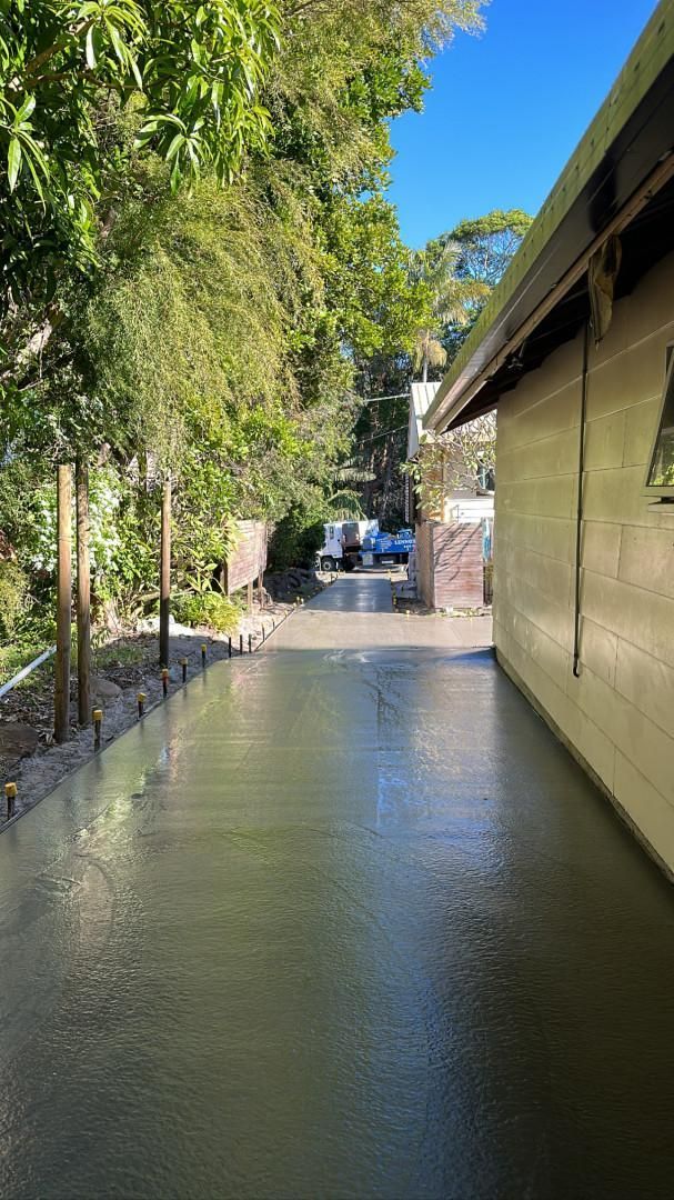 A Concrete Walkway Leading To A House With Trees In The Background — Hinterland Concreting Pty Ltd In Lennox Head, NSW