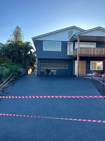 A Large House With A Concrete Driveway In Front Of It — Hinterland Concreting Pty Ltd In Ballina, NSW