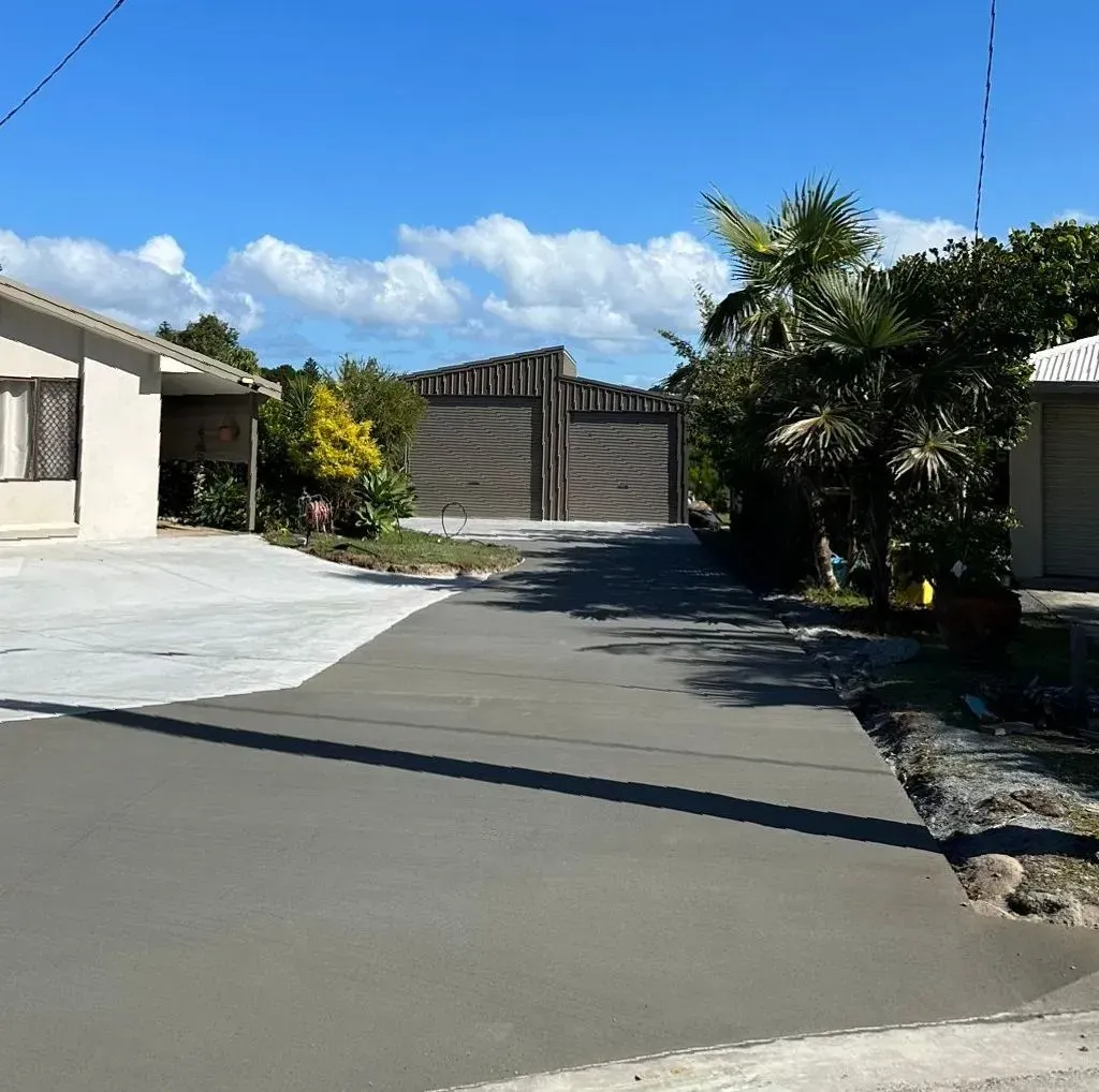 A Concrete Driveway Leading To A House On A Sunny Day — Hinterland Concreting Pty Ltd In Lennox Head, NSW