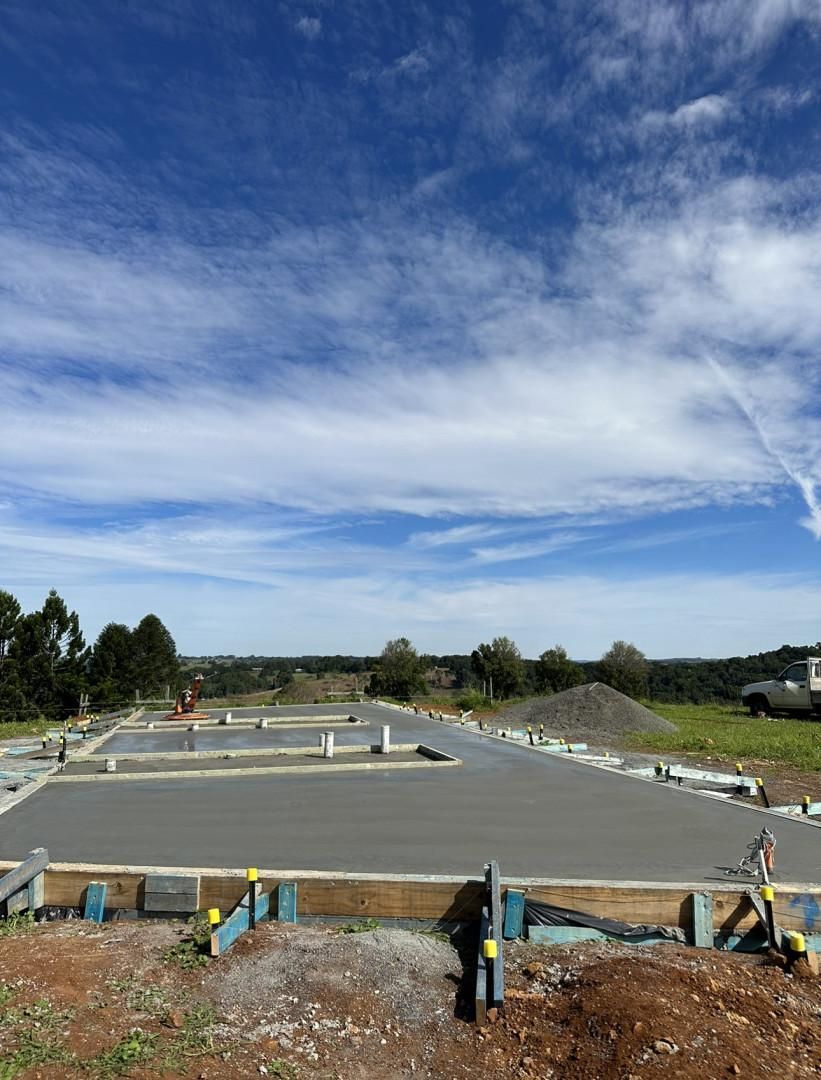 A Concrete Base For A House Is Being Built In A Field On A Sunny Day — Hinterland Concreting Pty Ltd In Lennox Head, NSW